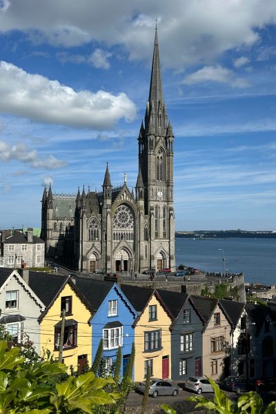St. Colman's Cathedral overlooking colorful houses in Cobh harbor, County Cork, Ireland, July 2025