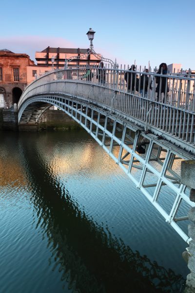 People going on Ha'penny Bridge, Liffey River in Dublin, Ireland